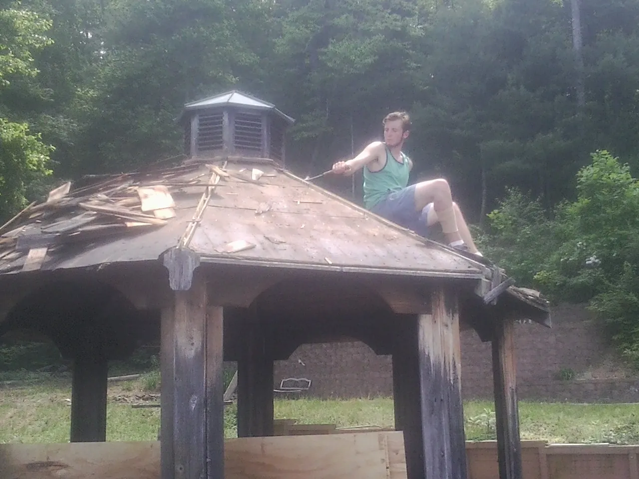 Tearing the old roof off a wooden gazebo before new shakes in Boise