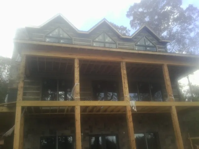 Dormers and porch framing on a large log home under construction — Roof Coating work by our crew in Boise